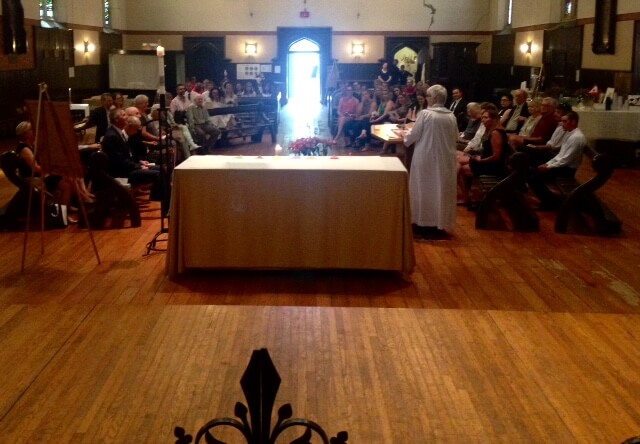 priest walking in front of altar during a service at Holy Trinity