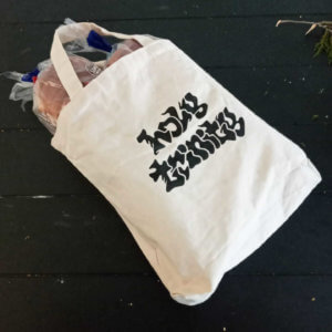 photo of a cloth shopping bag full of bread. Holy Trinity is printed on the bag.