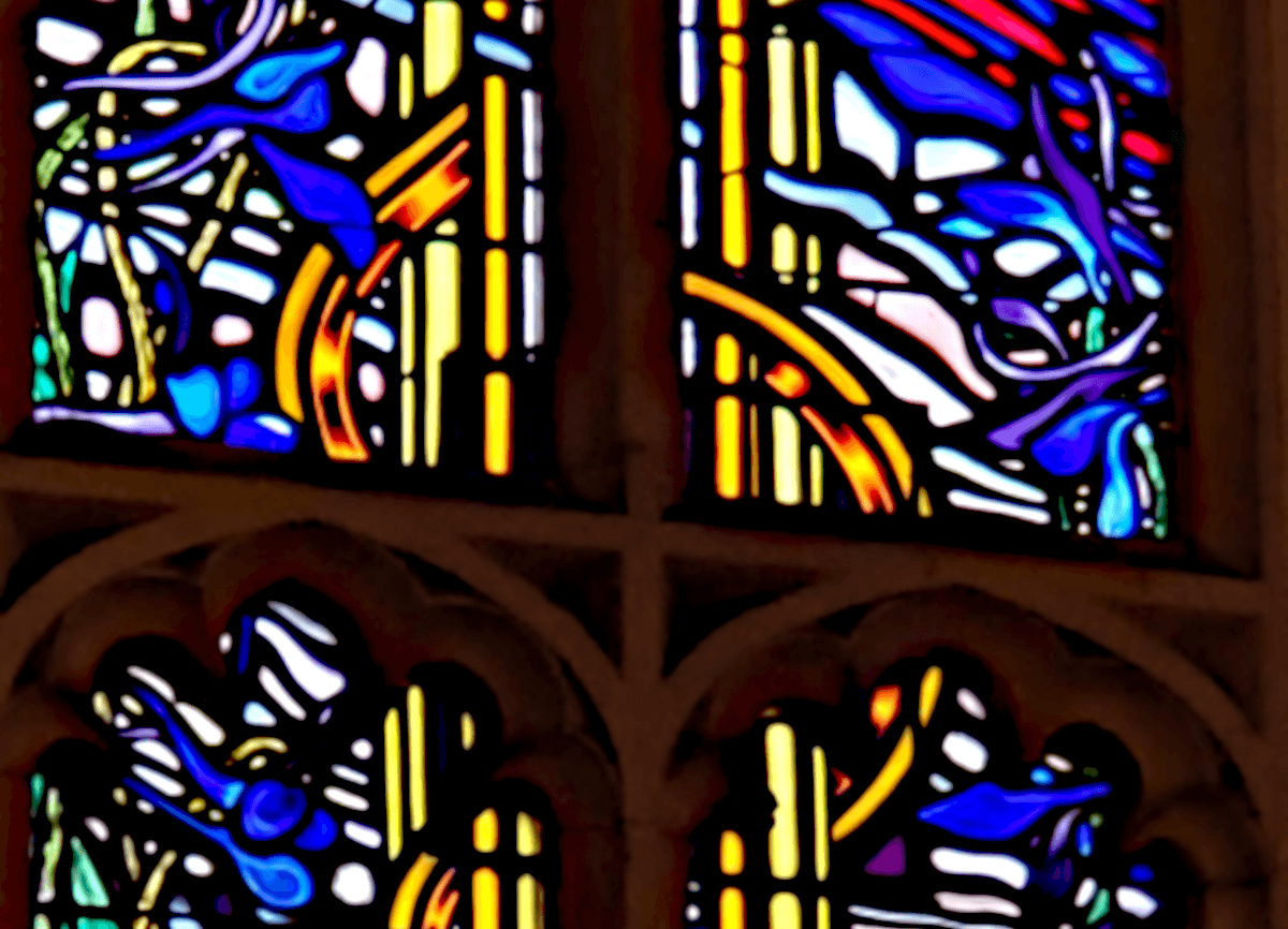 a close up of a stained glass window in blues and yellows.