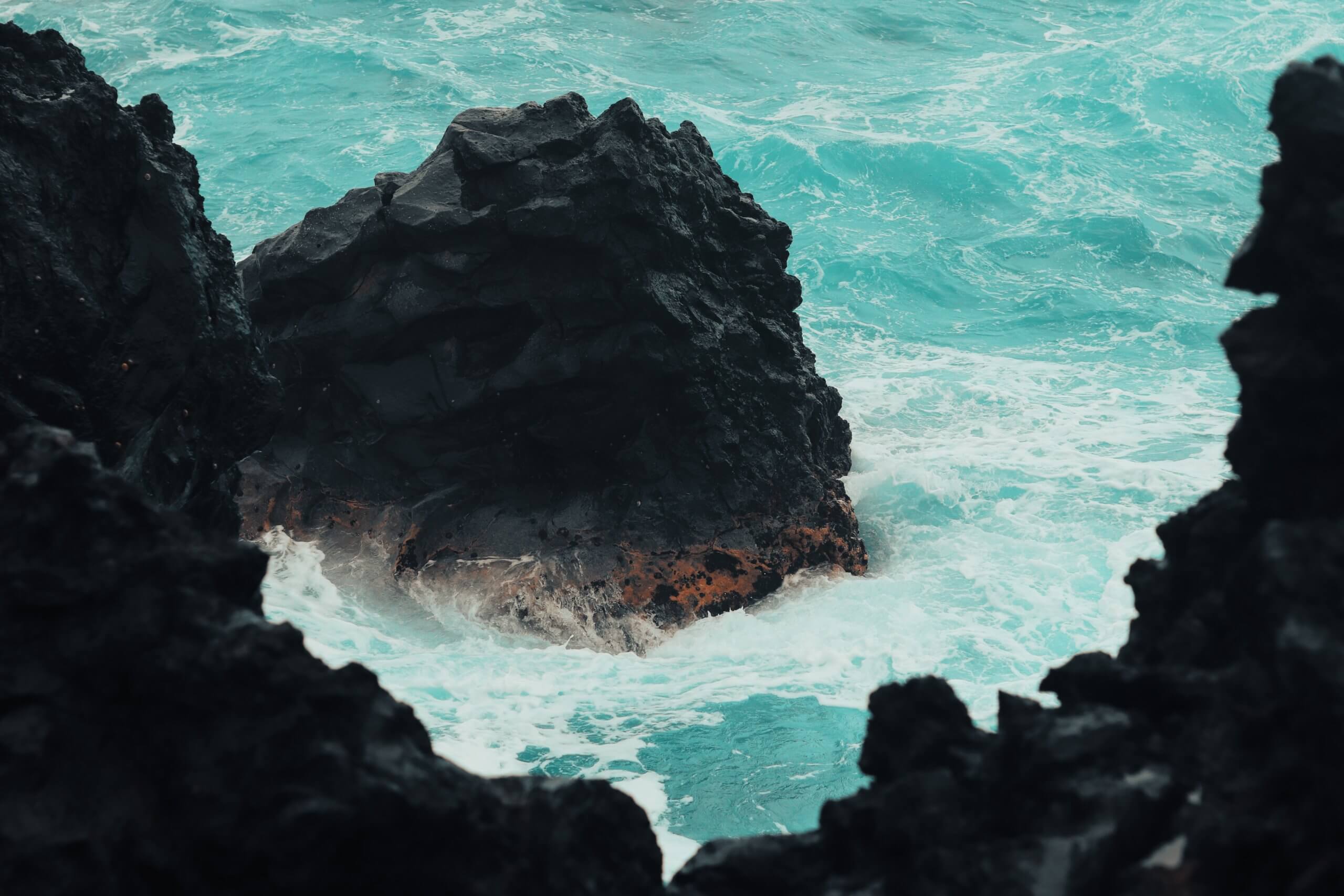 Photo of black rock and ocean waves. Photo by Lo Sarno on Unsplash