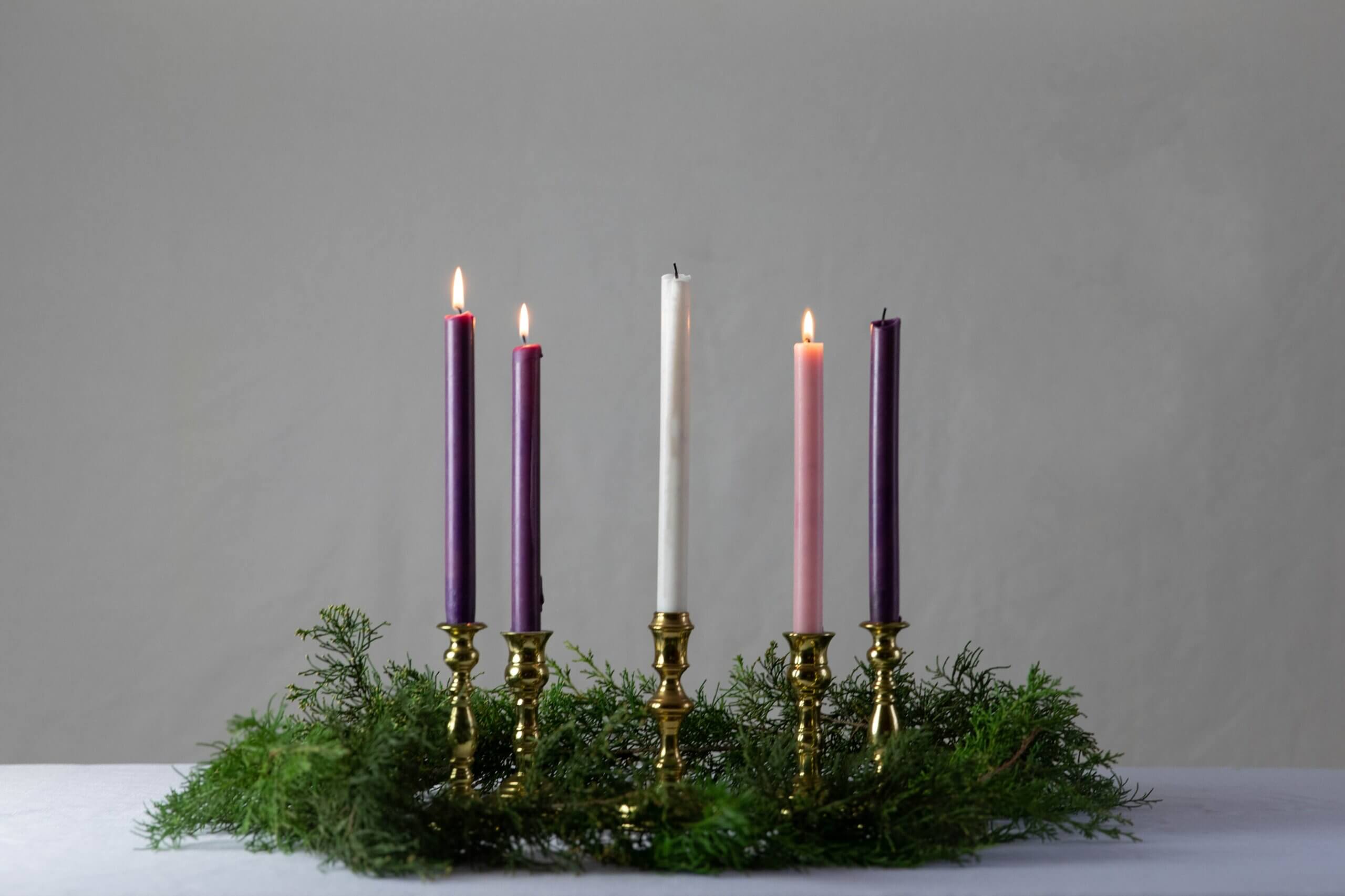 an advent wreath with three candles lit